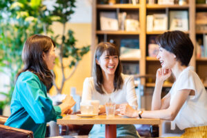 本棚のあるカフェで会話をしている3人の女性